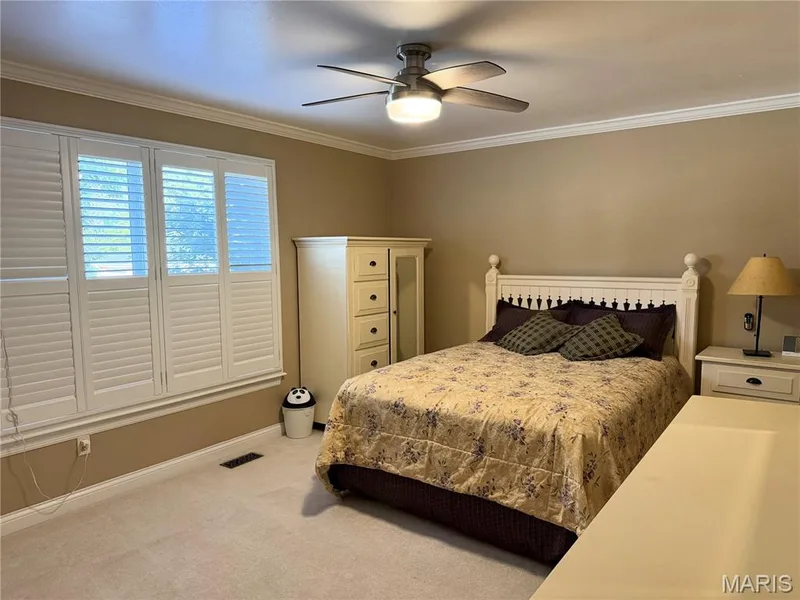 White plantation shutters, crown molding, ceiling fan with integrated lighting, and neutral wall tones — 14238 Kinderhook Drive, Chesterfield, MO 63017