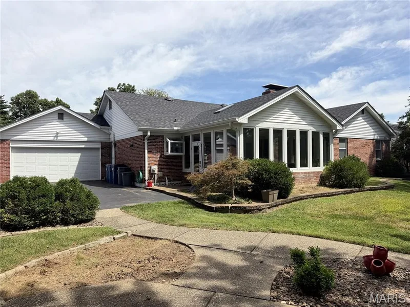 Brick exterior with white siding accents and a sunroom. two car rear entry garage — 14238 Kinderhook Drive, Chesterfield, MO 63017