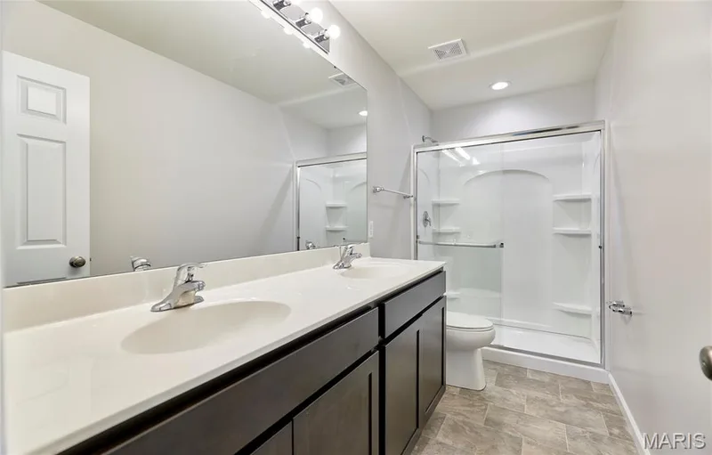 The primary ensuite bath features dual sinks and walk in shower. — 133 Day Lily Lane, Wentzville, MO 63385