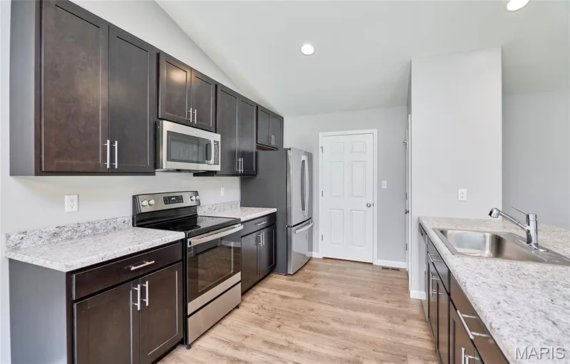 Custom Cabinets and plenty of them along with stainless steel appliances including refrigerator. — 133 Day Lily Lane, Wentzville, MO 63385