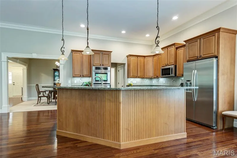 Large granite covered center island. Photos give green appearance but definitely not the case. — 1209 Silver Fern Drive, Lake St. Louis, MO 63367