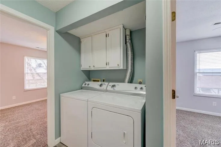 Dedicated laundry area featuring white cabinetry and light blue walls — 1430 Summergate Parkway #J, St Charles, MO 63303