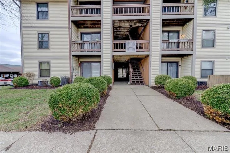 Multi-story building featuring light-colored siding and dark-framed windows — 1430 Summergate Parkway #J, St Charles, MO 63303