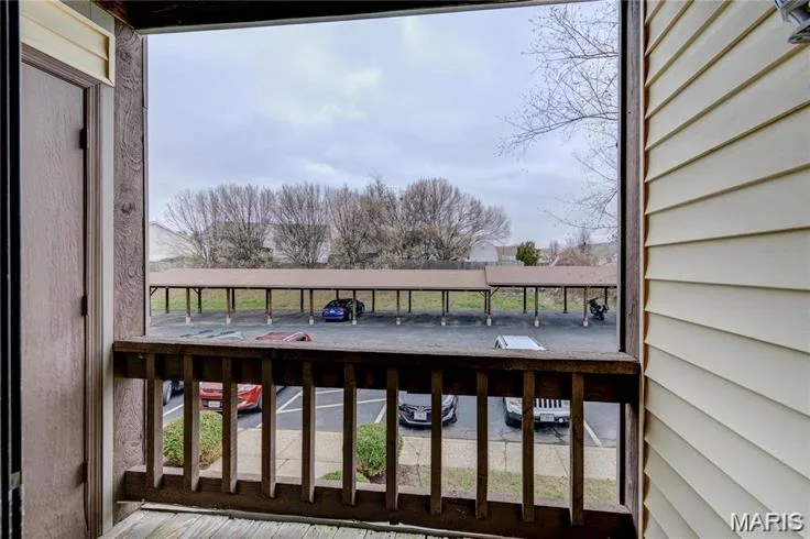 Private balcony featuring wood-finish railing and siding — 1430 Summergate Parkway #J, St Charles, MO 63303
