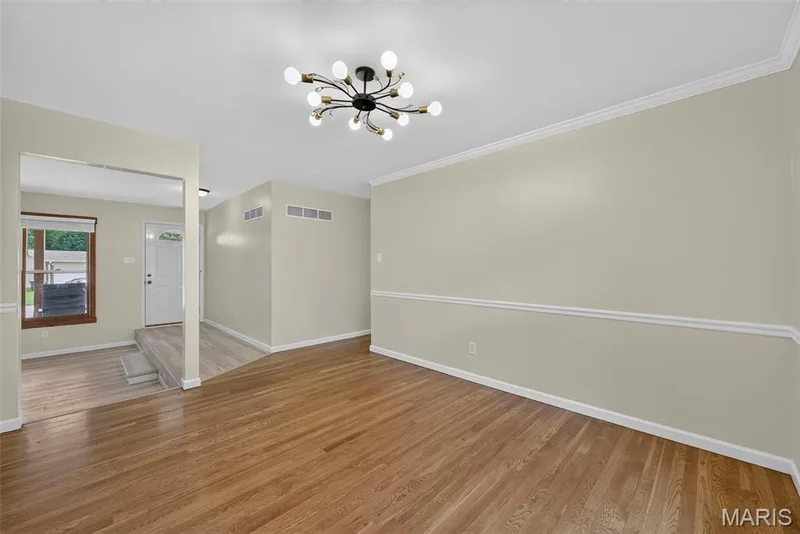 Dining room off the living room. The dining room has hard wood flooring and crown molding — 208 Meadowlark Lane, St Charles, MO 63301