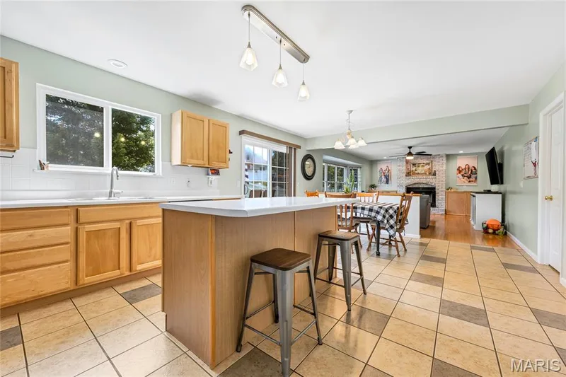 Pendant lighting about the island adds to the abundance of natural light that flows in the kitchen. — 2304 Bear Fountain Run, Wentzville, MO 63385