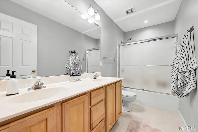 A full hall bath can be found on the second level of the home with dual sinks and a tub/shower combo that has glass doors for privacy. — 2304 Bear Fountain Run, Wentzville, MO 63385
