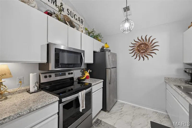 Kitchen featuring white cabinetry, stainless steel appliances including an oven with an overhead microwave — 974 Windstream Drive #38, St Peters, MO 63376