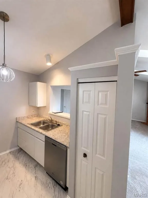 Kitchenette featuring a stainless steel double sink, light-toned countertop, and white cabinetry with a built-in stainless steel dishwasher — 974 Windstream Drive #38, St Peters, MO 63376