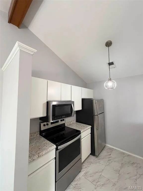Kitchen featuring vaulted ceilings, light-toned cabinetry, stainless steel appliances, and patterned tile flooring — 974 Windstream Drive #38, St Peters, MO 63376