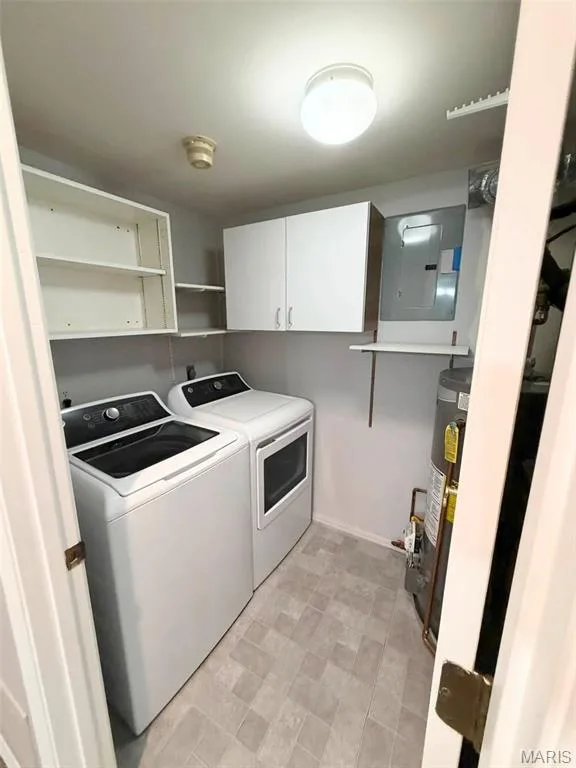 Laundry area featuring overhead cabinetry, open shelving, and a patterned tile floor — 974 Windstream Drive #38, St Peters, MO 63376