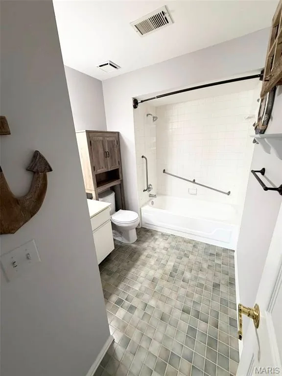 White subway tile tub surround, white porcelain bathtub, and gray square tile flooring — 974 Windstream Drive #38, St Peters, MO 63376