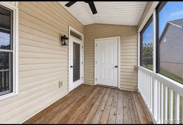 Screened porch featuring wood-finish flooring, white railing, and a ceiling fan — 2514 S Larksong Drive, Grover, MO 63040