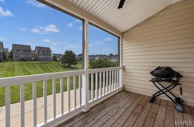 Screened porch with wood-finish flooring, white railing, and a sloped ceiling — 2514 S Larksong Drive, Grover, MO 63040