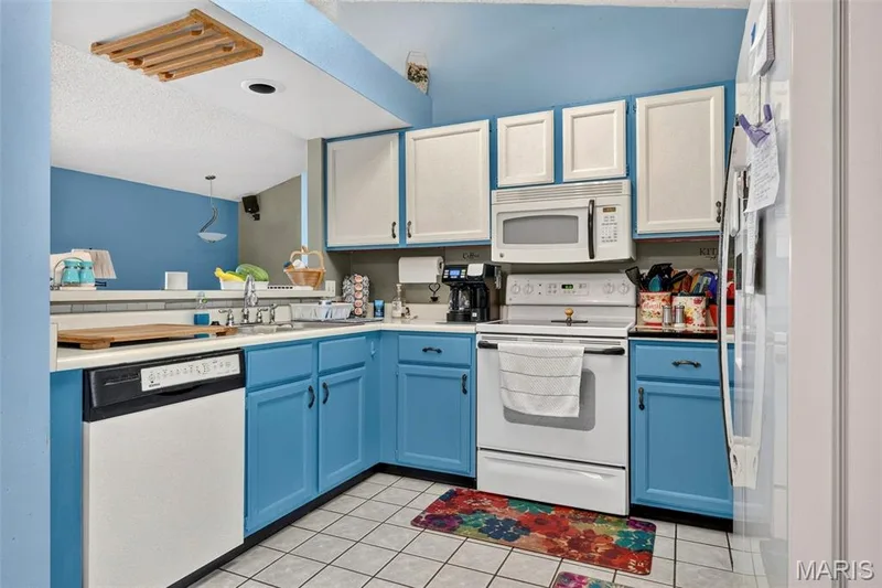 Kitchen featuring a double basin sink, white countertops, Electric range stove, dishwasher, and Microwave — 17 Kingspointe Court, St Peters, MO 63376