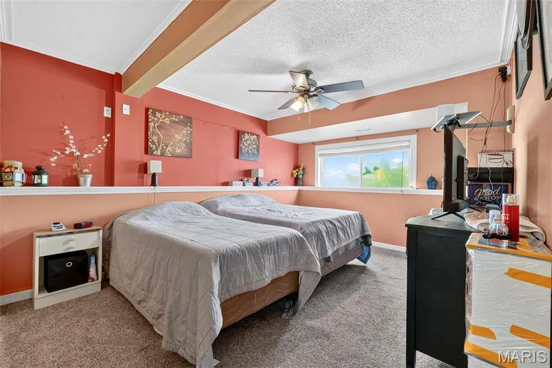Carpeted room featuring a ceiling fan, a window, and a built-in shelf — 17 Kingspointe Court, St Peters, MO 63376