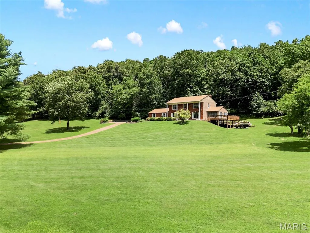 Expansive green lawn bordering a natural wooded area — 3672 Hawks Rest Road, Wildwood, MO 63069