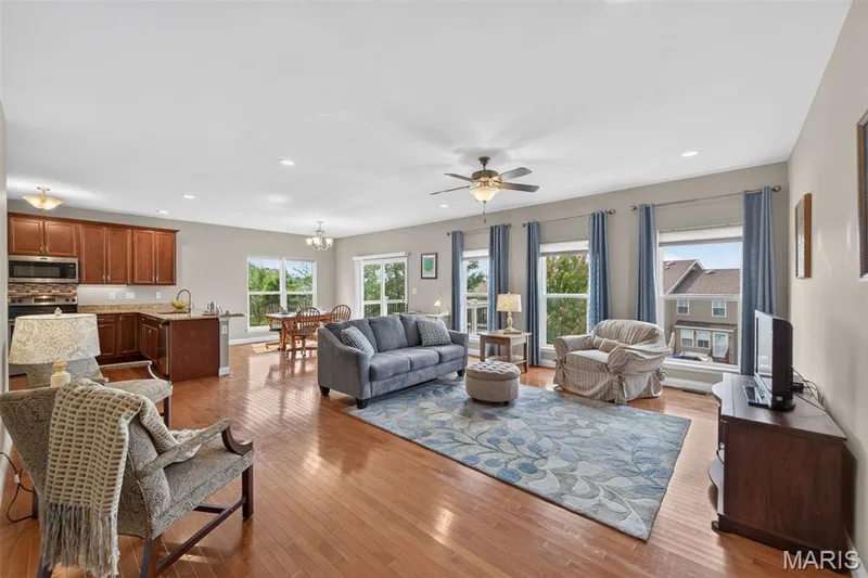 Open-concept living area with wood-finish flooring throughout — 1125 Duxbury Lane, O'Fallon, MO 63366