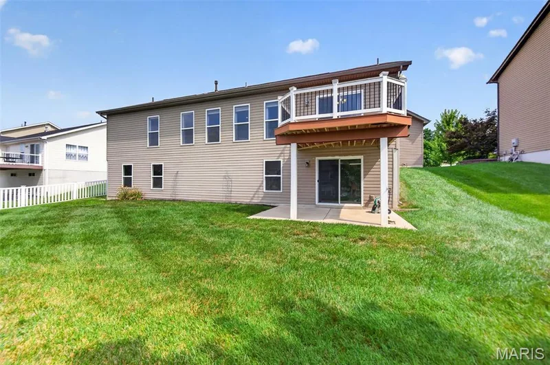 Two-story design with a second-level deck and a lower-level patio — 1125 Duxbury Lane, O'Fallon, MO 63366