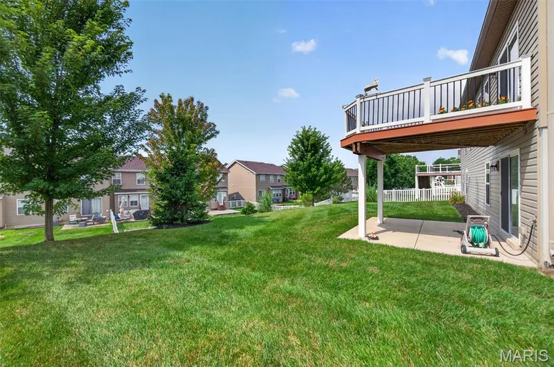 Spacious backyard featuring a large green lawn — 1125 Duxbury Lane, O'Fallon, MO 63366