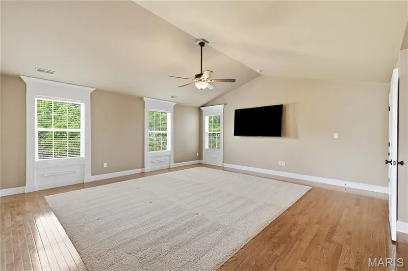 Spacious Primary bedroom featuring vaulted ceiling, large windows with elaborate wood trim from floor to ceiling — 5500 Wooded Creek Drive, O'Fallon, MO 63304