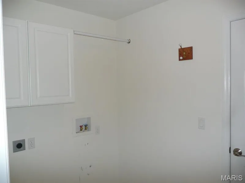 Main floor laundry room with cabinets and hanging rod. — 118 Fallon Villa Court, O'Fallon, MO 63368