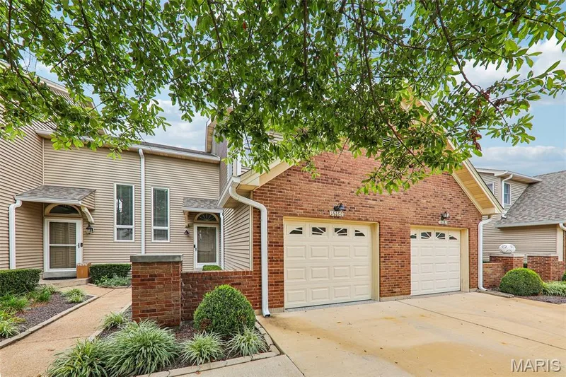 Brick and siding exterior featuring a two-car garage with individual doors — 16180 Lea Oak Court, Chesterfield, MO 63017