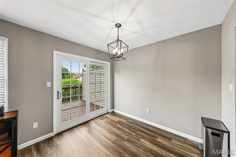 Room featuring wood-finish flooring, a contemporary geometric chandelier, and light gray walls — 16180 Lea Oak Court, Chesterfield, MO 63017