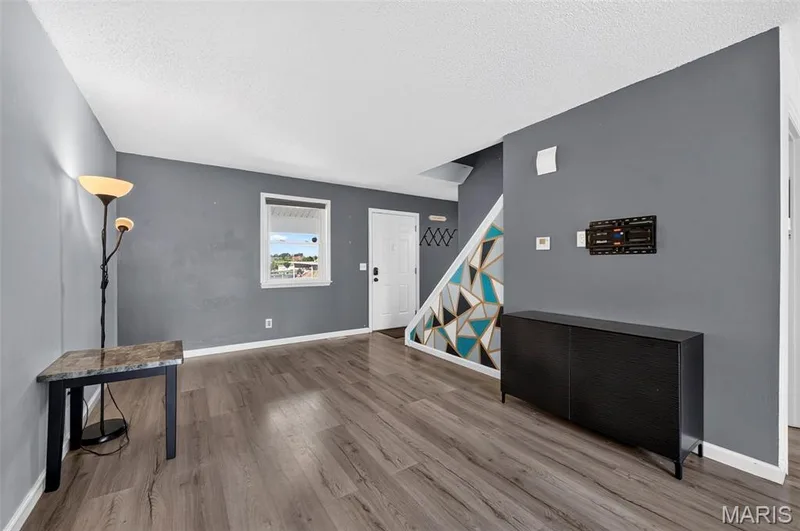 Living Room with view of the Front Door/Window and the Stairs to the Upper Level — 2701 Falcons Way #132, St Charles, MO 63303