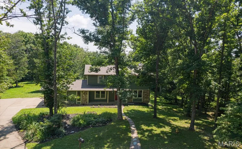 Traditional-style home featuring a gabled roofline and green siding — 44 Wilderness Lane, Defiance, MO 63341