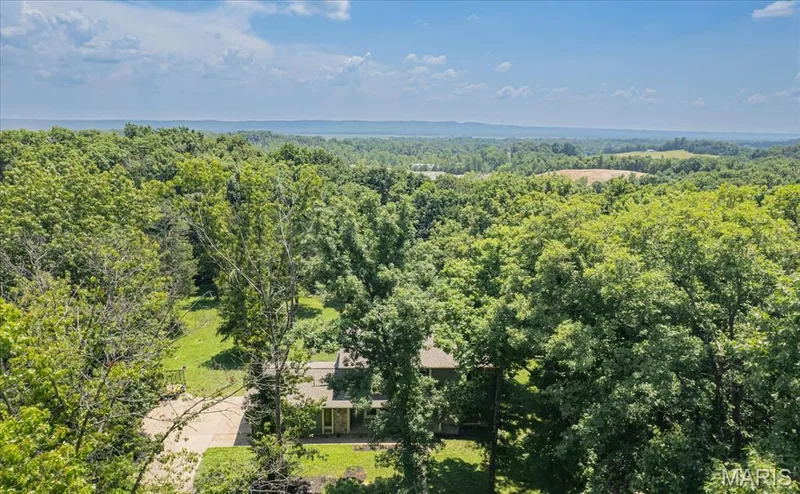 Extensive tree coverage surrounds the property, offering a private setting — 44 Wilderness Lane, Defiance, MO 63341