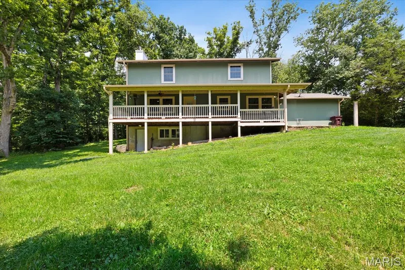 Rear view of home featuring a covered upper deck  and a lower-level walk-out — 44 Wilderness Lane, Defiance, MO 63341