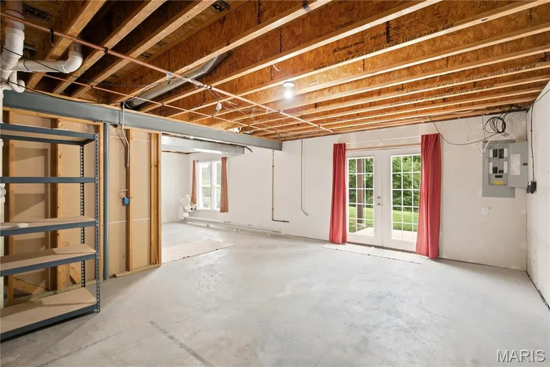 Unfinished basement space featuring exposed wood joists and concrete flooring — 704 Harrier Drive #V, Lake St. Louis, MO 63367