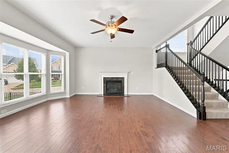 See Virtually Staged Photo for your imagination - Open Floor Plan to Kitchen and Breakfast Area with a 6-Window Bay and a Gas Fireplace, and wood-look solid surface flooring throughout the main level. — 104 Towergate Drive, Lake St. Louis, MO 63367