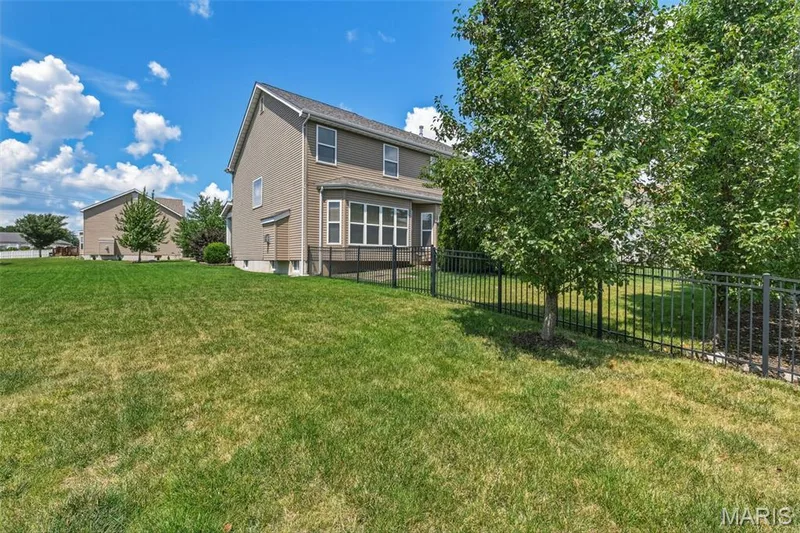 Enjoy the outdoors from the private back porch overlooking a spacious, level backyard. Black ornamental fencing, mature landscaping, and plenty of green space create an ideal setting for entertaining, pets, play, or relaxing evenings at home. — 104 Towergate Drive, Lake St. Louis, MO 63367