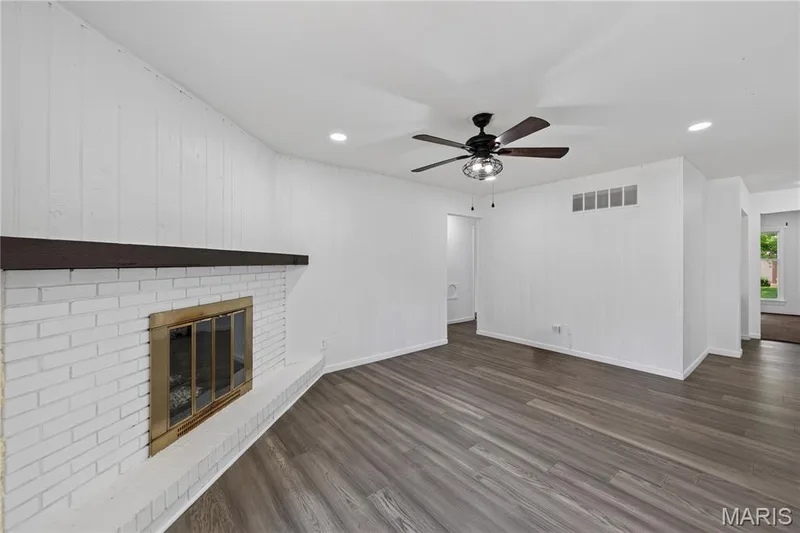 Family Room with Corner Wood Burning Fireplace and Luxury Vinyl Plank Flooring — 608 Mosport Drive, St Charles, MO 63304