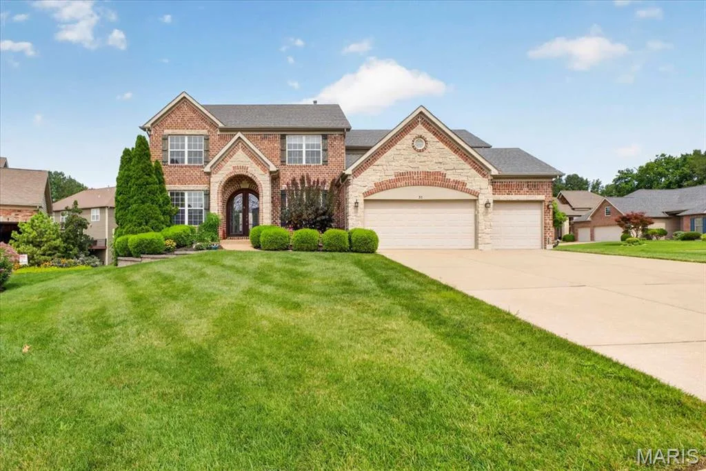The Brick and Stone elevation on this home is stunning.  Gorgeous set back showing the architectural detail of the home and three car garage with large driveway. — 31 Pinewood Court, Dardenne Prairie, MO 63368