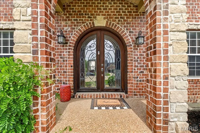 The brick and stone covered front porch accent the beautiful arched front door. — 31 Pinewood Court, Dardenne Prairie, MO 63368