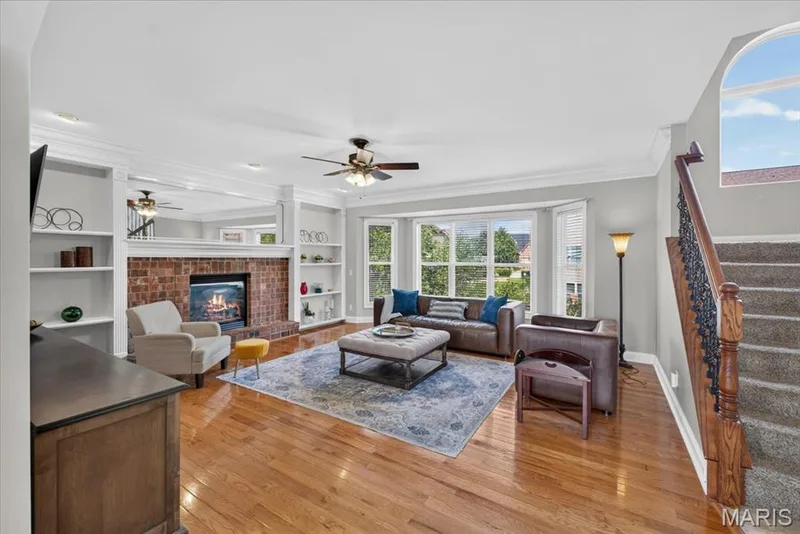 The Great Room is expansive, with wood flooring, large brick gas fireplace with built-ins and a 5-Bay window overlooking the back yard. — 31 Pinewood Court, Dardenne Prairie, MO 63368