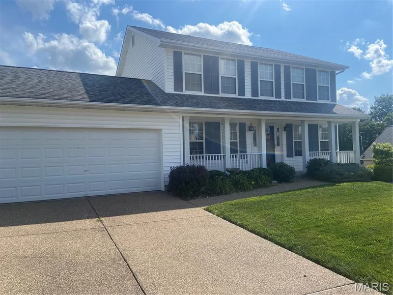 Two-story residence featuring white siding and a covered front porch with white railings — 1113 Treeshade Drive, St Peters, MO 63376