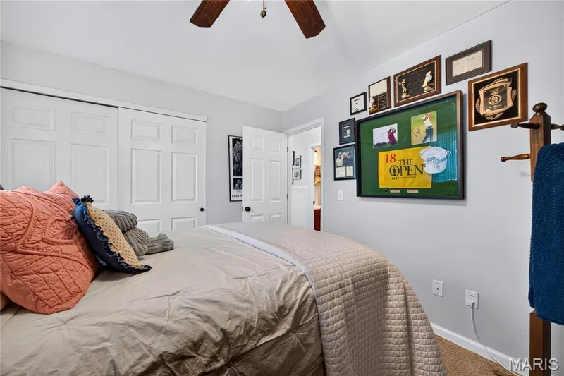 Bedroom featuring light gray wall paint, wood-finish ceiling fan, and carpeted flooring — 802 Barbara Place, O'Fallon, MO 63366