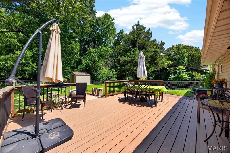 Multi-level deck featuring composite wood-finish decking and wood railings — 802 Barbara Place, O'Fallon, MO 63366