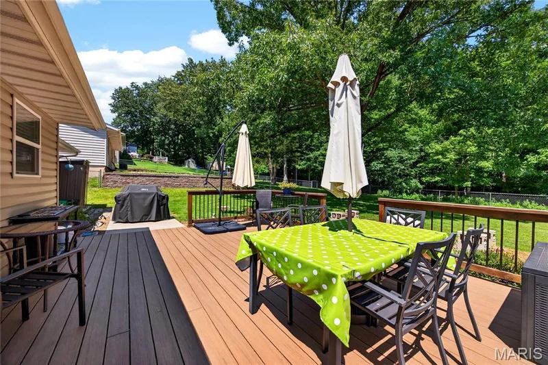 Spacious outdoor deck featuring composite decking and black metal railings — 802 Barbara Place, O'Fallon, MO 63366