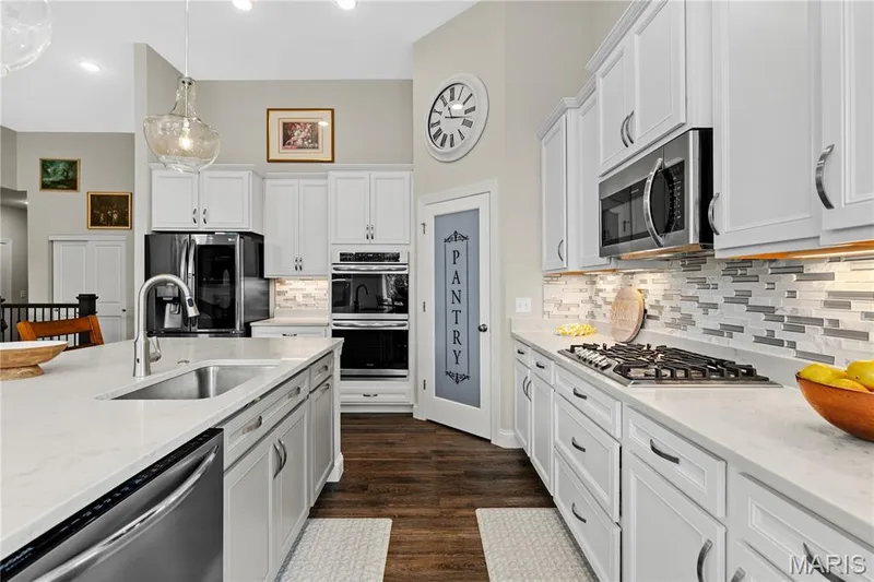 Walk-in pantry, stainless steel appliances, double ovens, and a gas cooktop make it as functional as it is beautiful. — 1316 Silver Fern Drive, Lake St. Louis, MO 63367