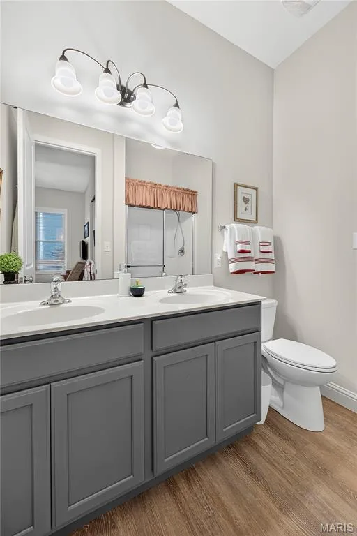 Owners Bath with Tall Wood Vanity with 2 Sinks, Vinyl Wood Laminate Floor, Tall Elongated Toilet and Full Length Mirror & Designer Light Fixtures! — 6170 Suntan Drive, St Charles, MO 63301