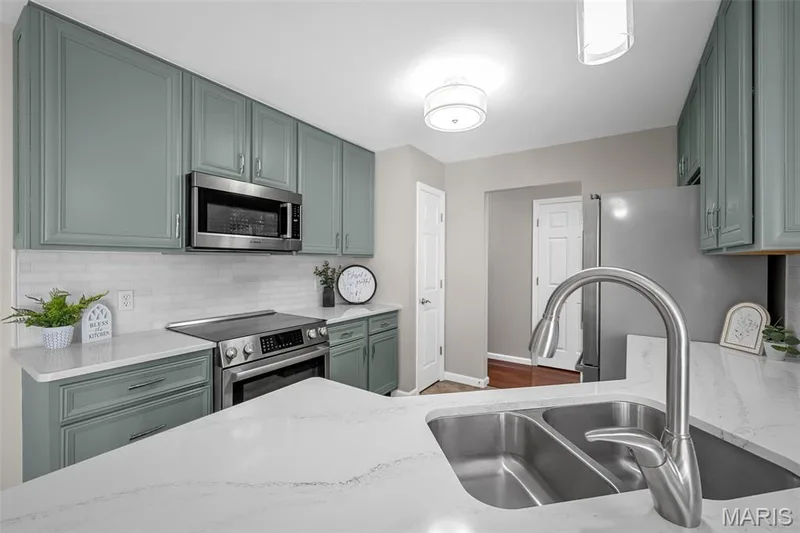 Updated kitchen with quartz countertops and high end Bosch smart appliances and marble backsplash with custom cabinetry. — 3416 Sun Bear Court #830C, Wentzville, MO 63385