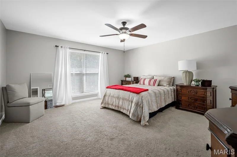 Primary bedroom with ceiling fan and nice size window and carpet. — 3416 Sun Bear Court #830C, Wentzville, MO 63385
