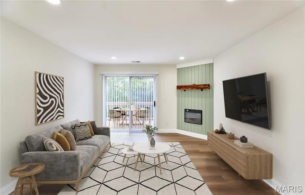 Living area featuring wood-finish Luxury vinyl plank flooring, recessed lighting, and a corner-mounted electric fireplace with a wood mantle and vertical paneling — 214 Sugar Lake Drive #5, St Peters, MO 63376
