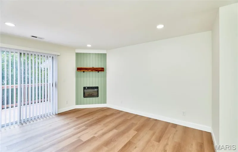 Spacious living room with wood-finish Luxury vinyl plank flooring and recessed lighting — 214 Sugar Lake Drive #5, St Peters, MO 63376