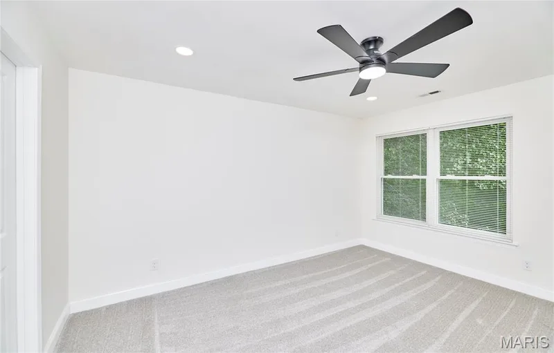 Bedroom featuring a ceiling fan with integrated lighting, recessed lighting, double-hung windows with blinds, and light-toned carpeting — 214 Sugar Lake Drive #5, St Peters, MO 63376